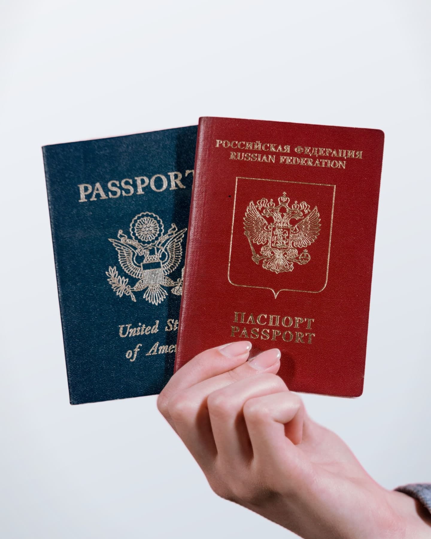 A hand holding U.S. and Russian passports